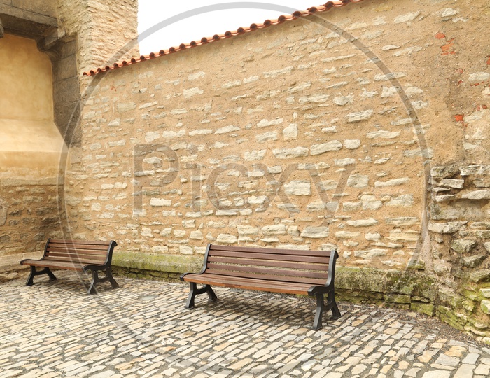 Benches alongside a rock wall building