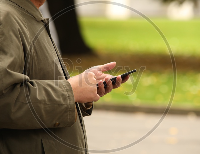 A Man Using Mobile in His Left hand Closeup Shot