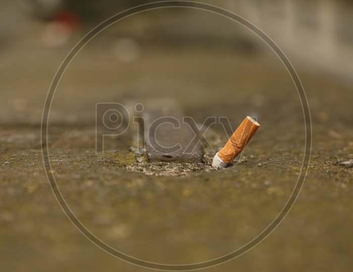 Image of A used cigarette crushed on the ground-OS004714-Picxy