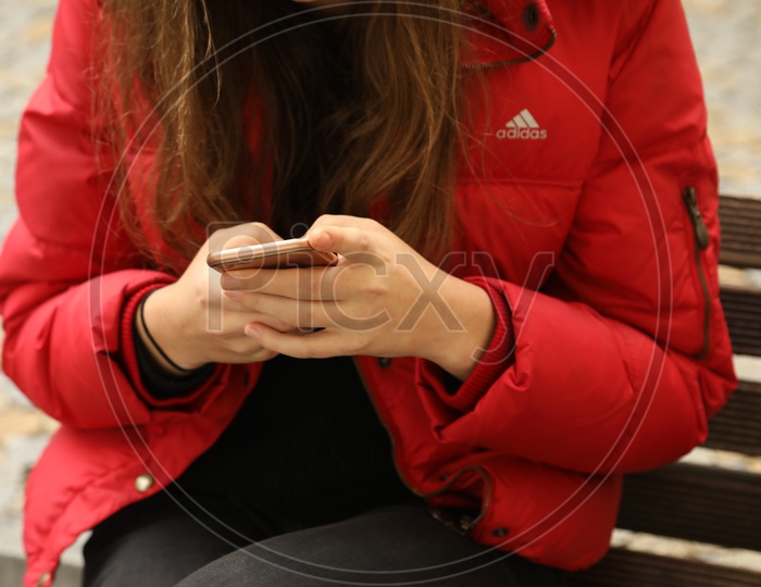 A woman holding a mobile phone in her hands