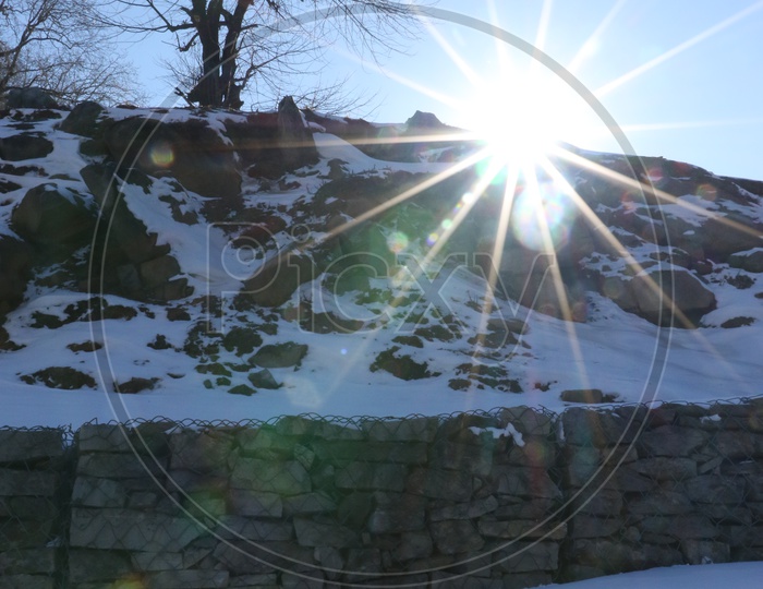 Hills with snow and a sun star