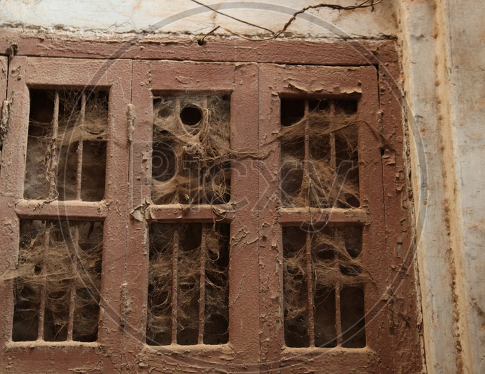 Unused window with spider webs