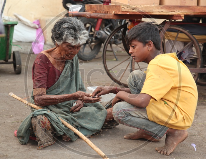 A beggar counting money along with a boy