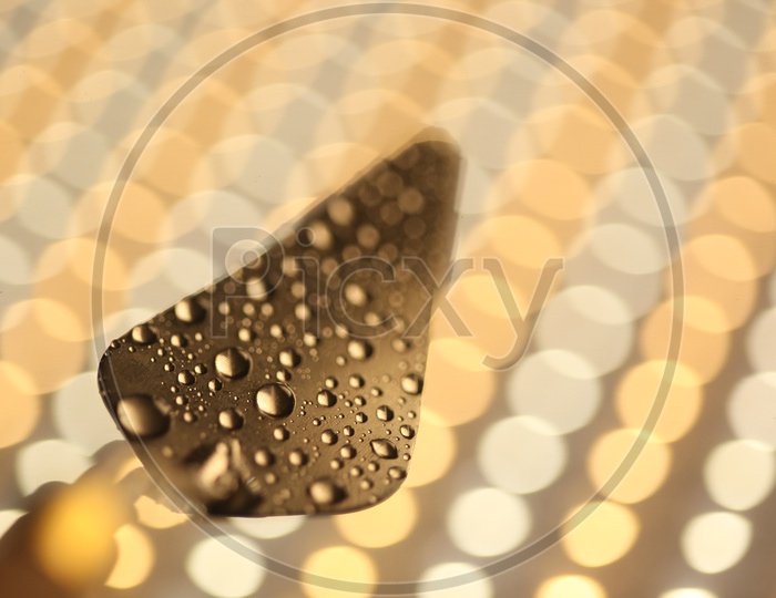 Spatula With Droplets On a  Led Background