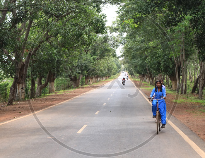 School girls on a bicycle on road