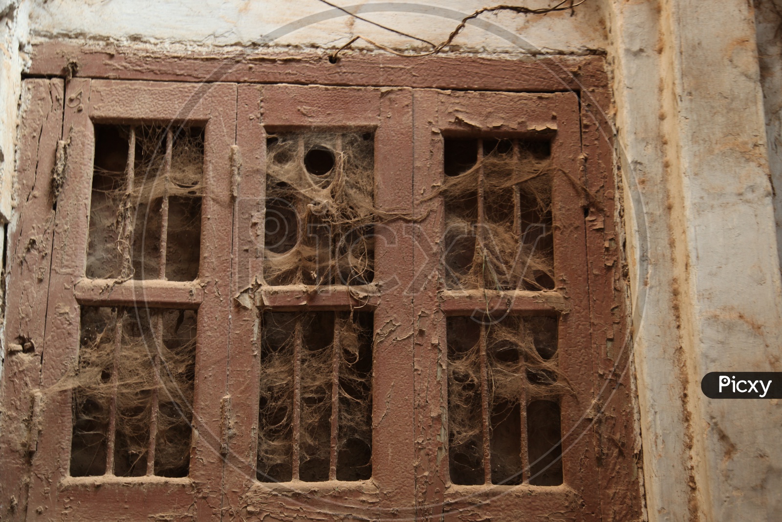 Unused window with spider webs