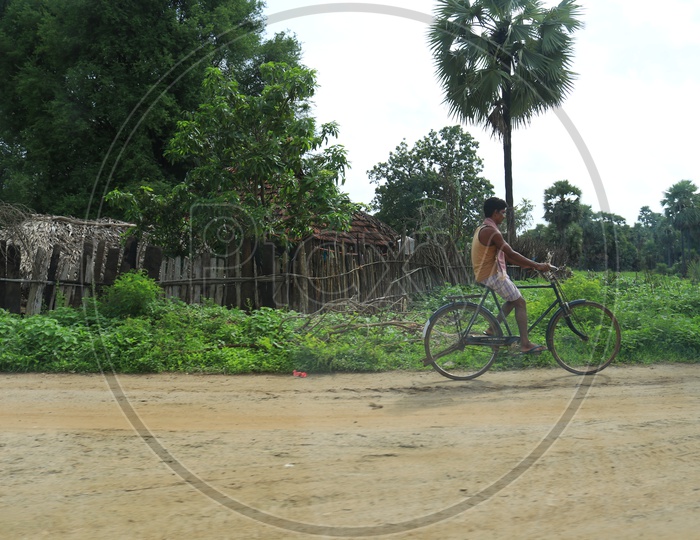 A man riding a bicycle on mud road