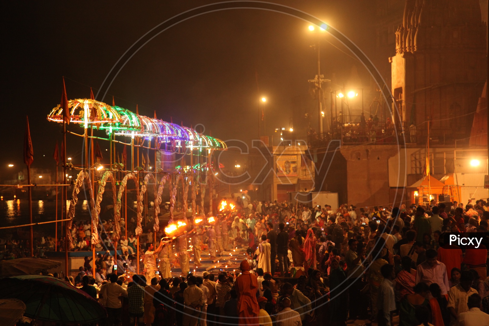 Devotees witnessing the Ganga Aarti performed by priests at Ganges river bank