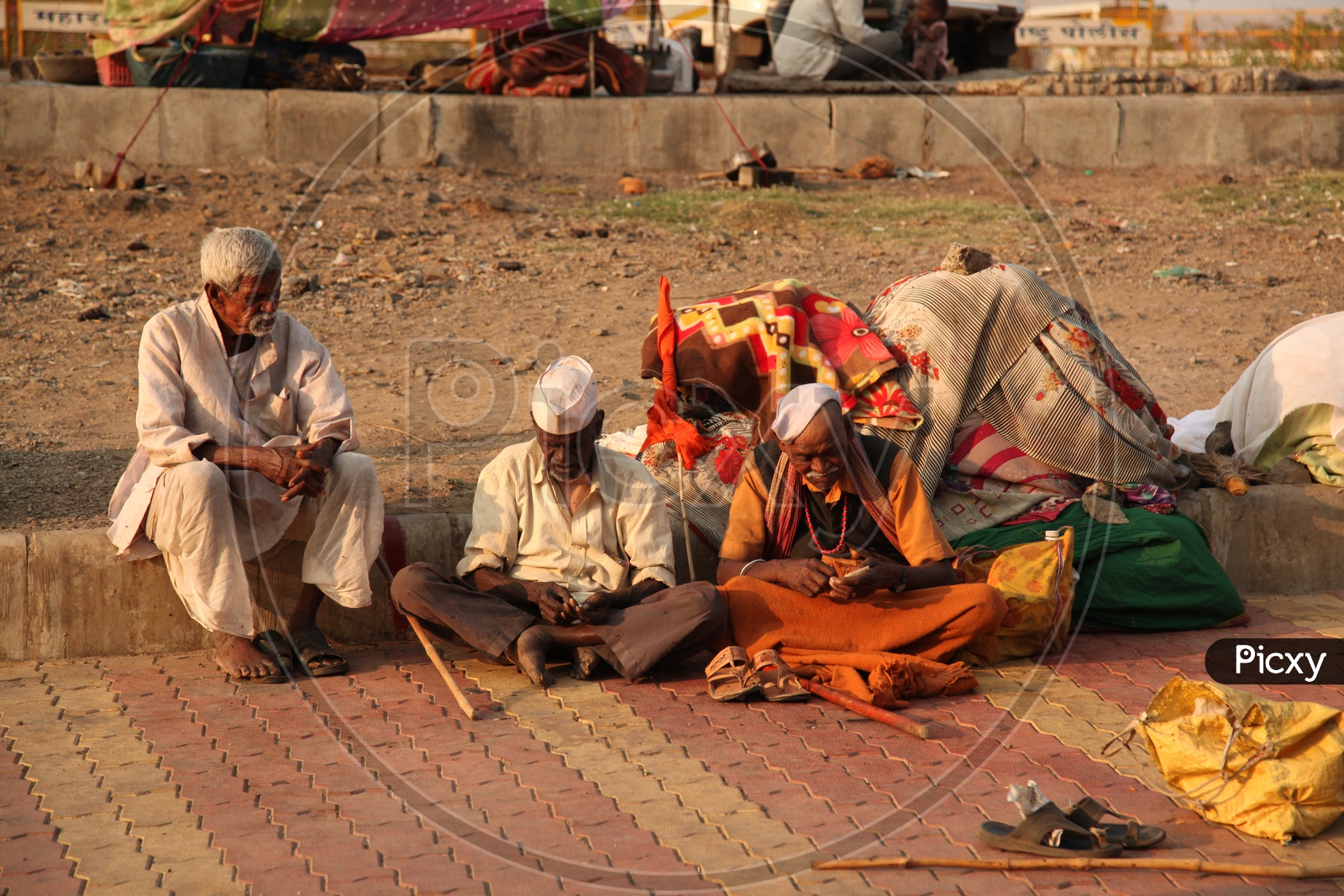 Three old men sitting on a road in Varanasi