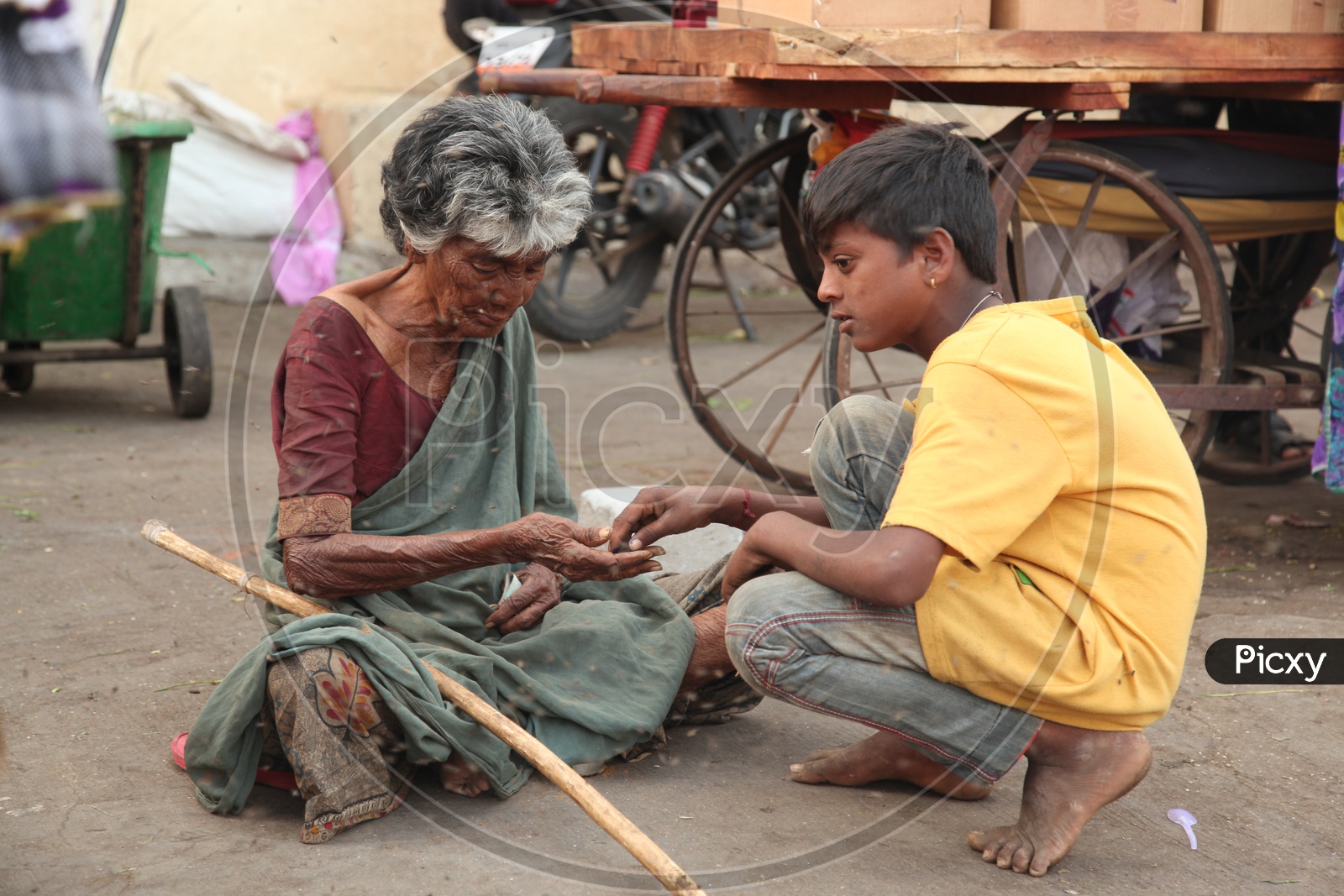 A beggar counting money along with a boy