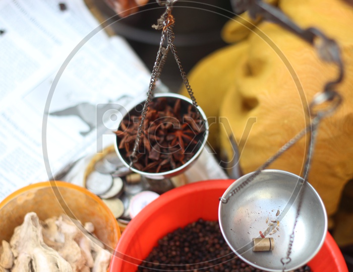 Star anise is weighed in a small weighing scale - Indian Spices