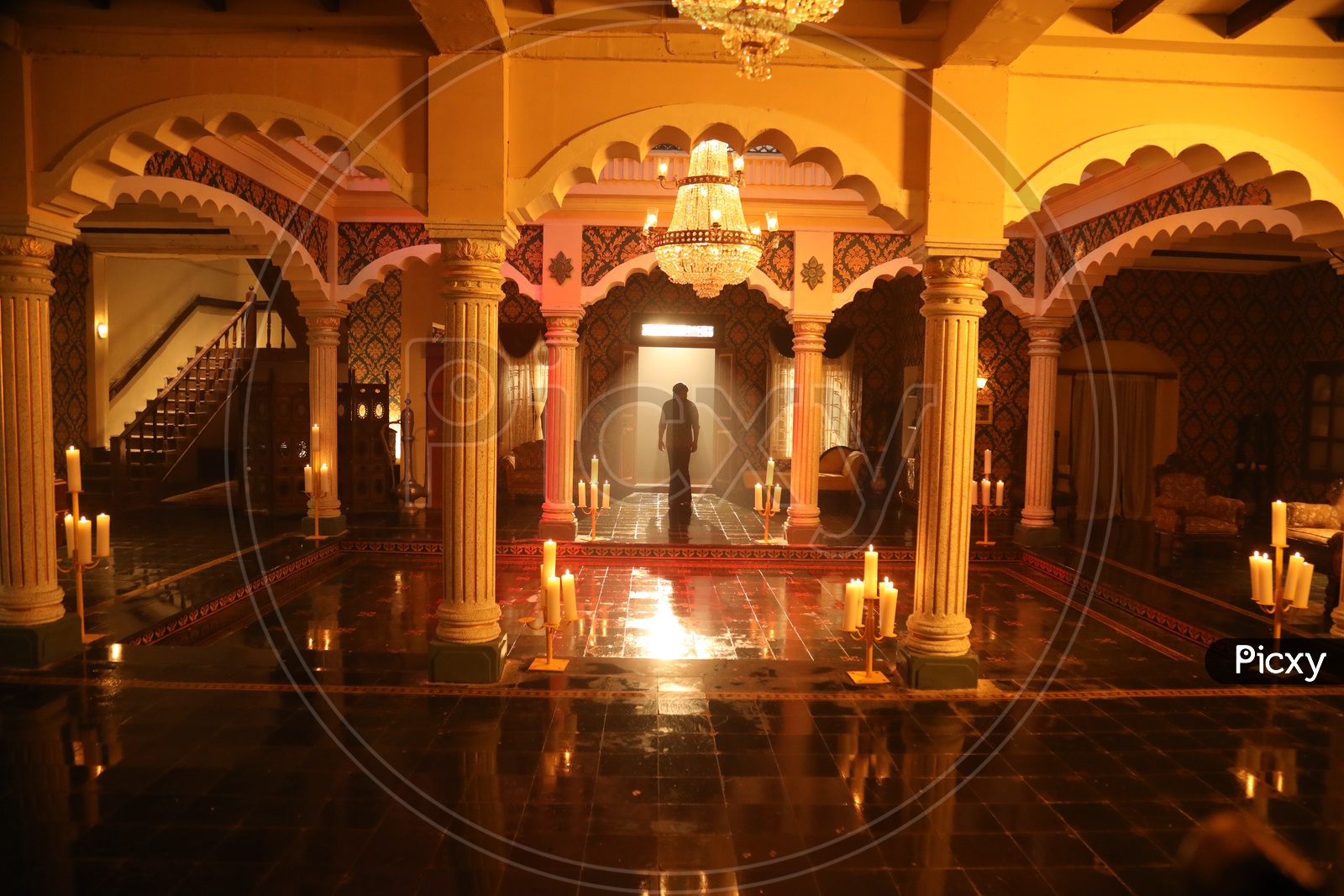 Man walking out of the Royal Indian court set up with a Throne and chandelier
