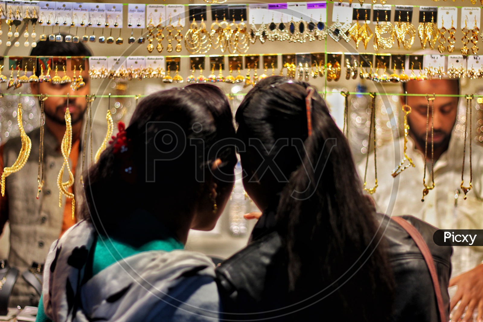 a couple of women looking at grooming jewellery on streets