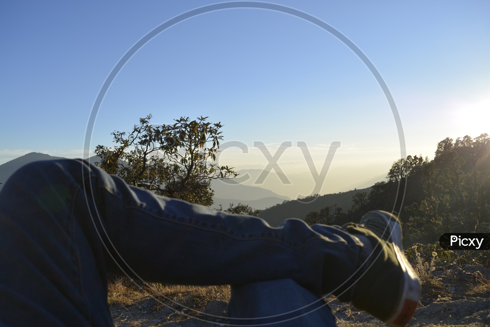 A tourist sitting cross legged on a mountain