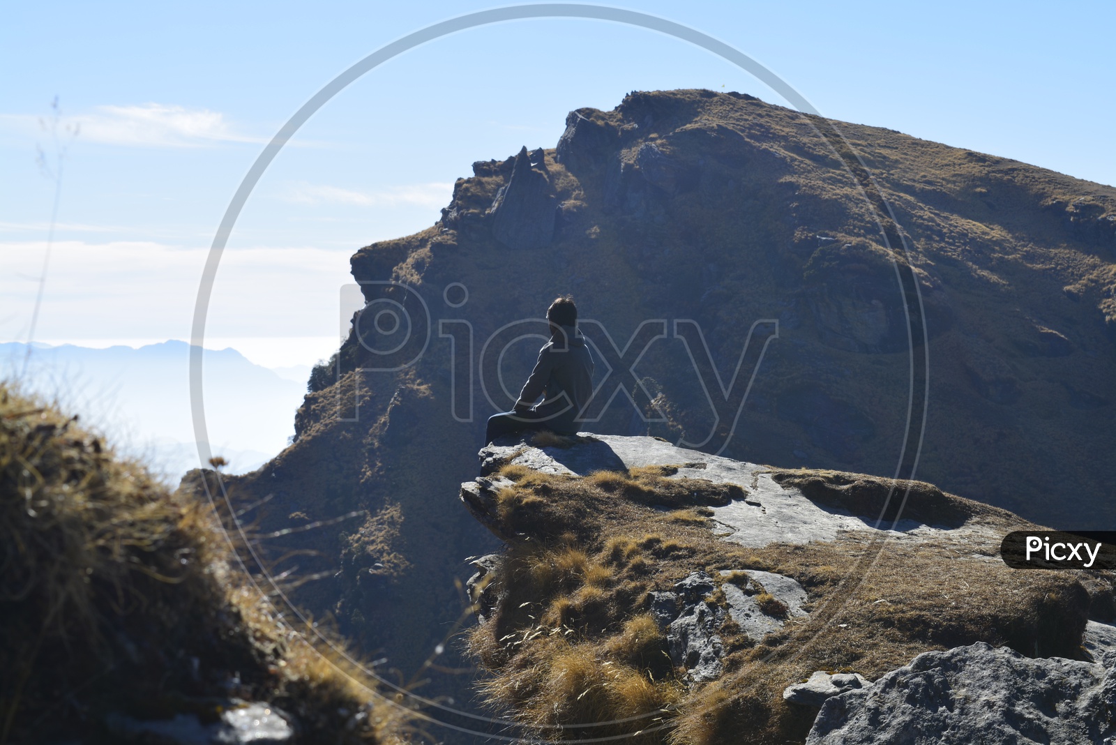Man sitting on the edge of the cliff