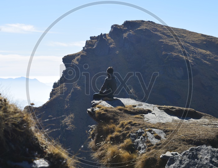 Man sitting on the edge of the cliff