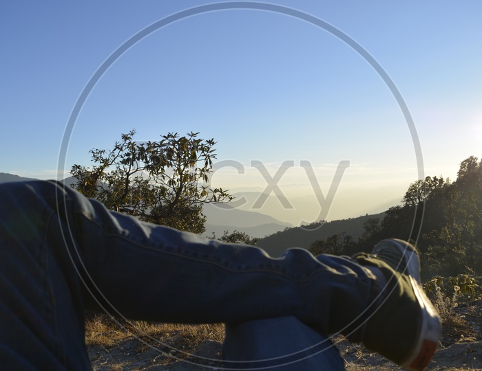 A tourist sitting cross legged on a mountain