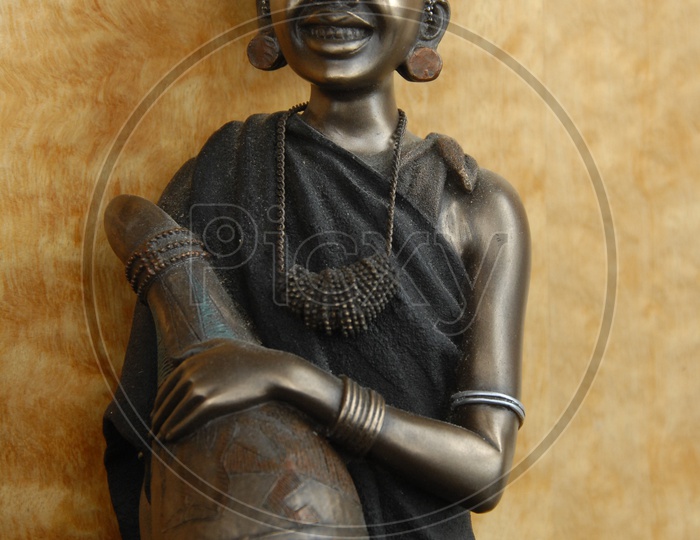 A smiling woman statue made out of metal