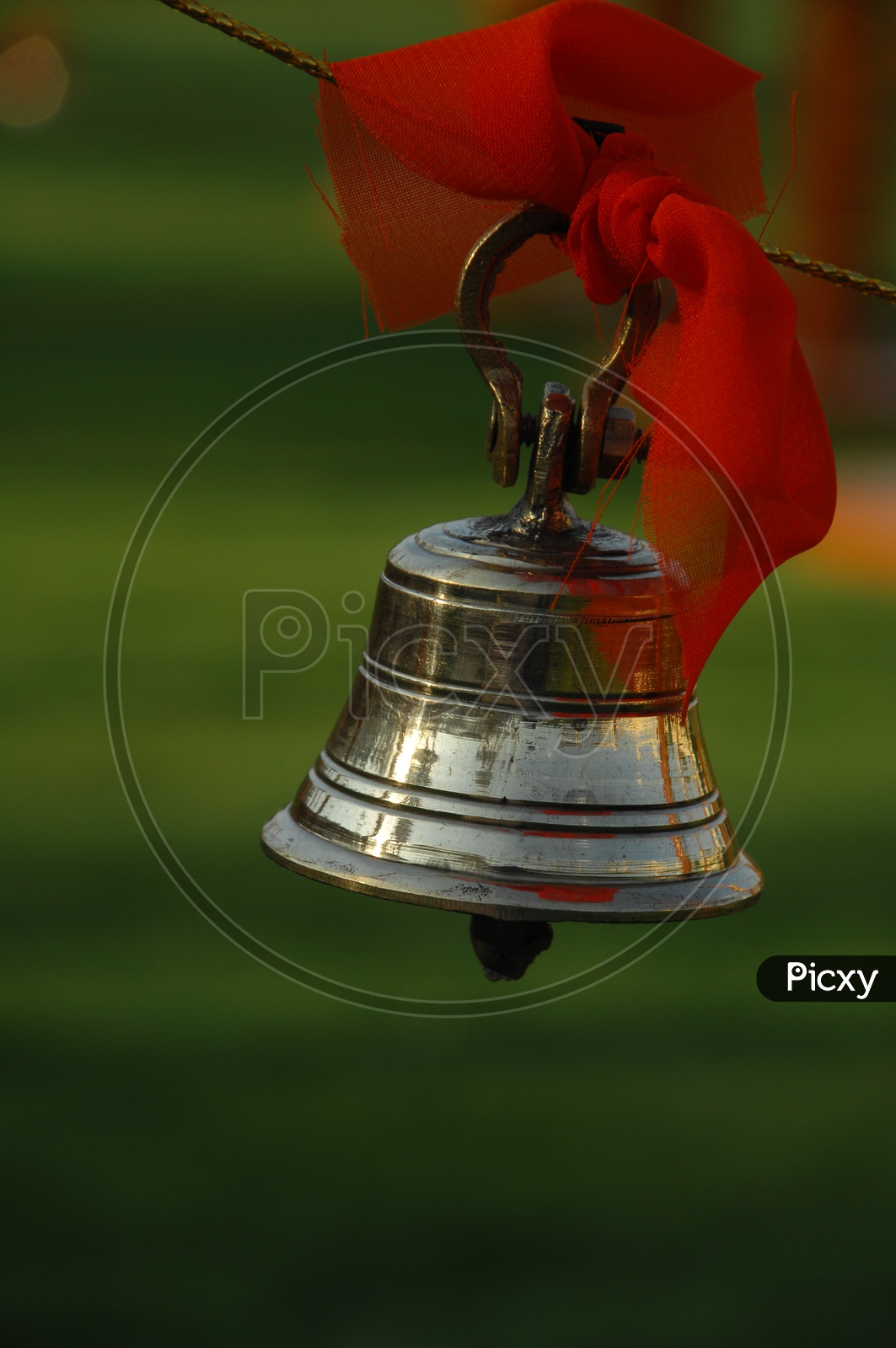 Metal bell tied to a rope with an orange cloth