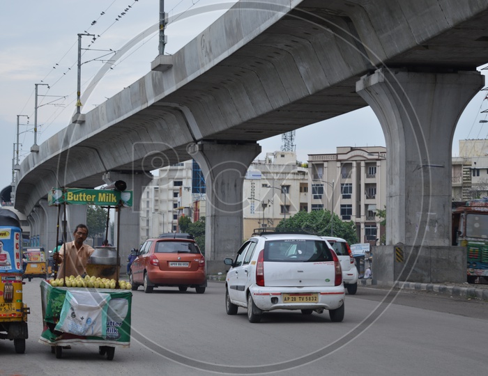 Vehicles moving on Hyderabad roads with Hyderabad metro rail  in background