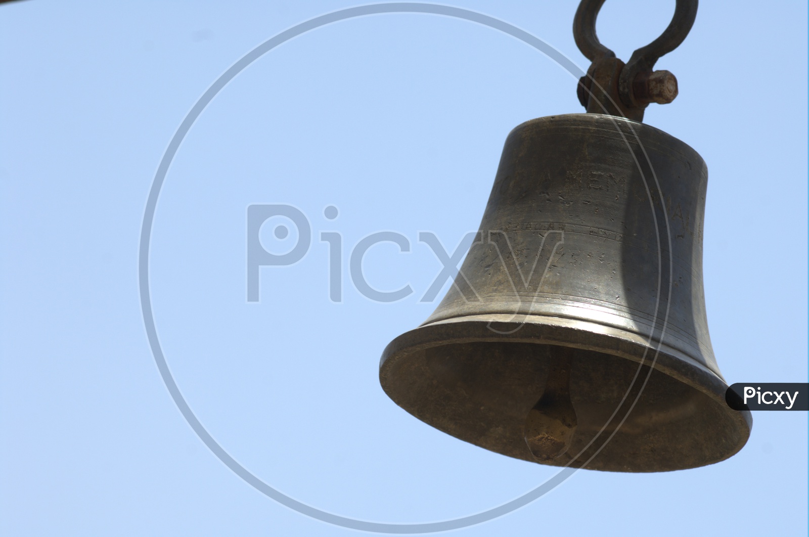 Hanging metal bell with sky background