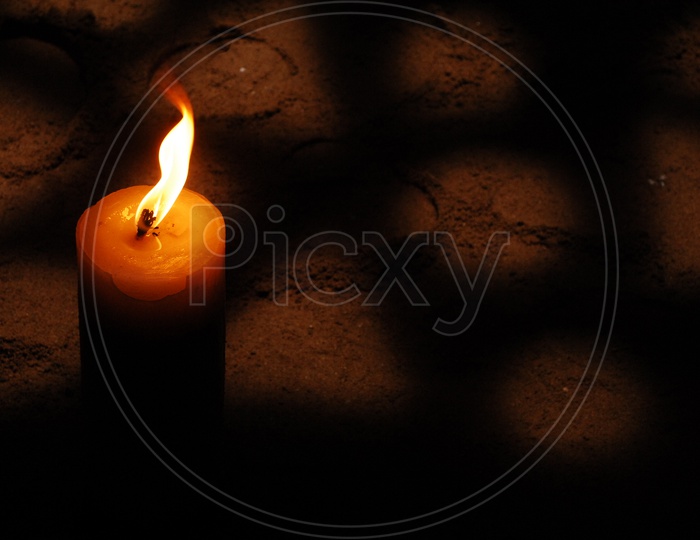 A lit candle with black background