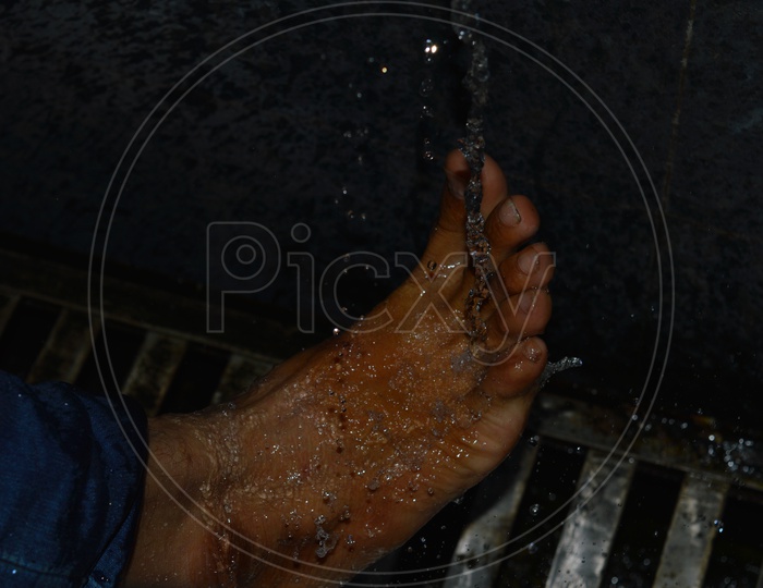 A Devotee washing his Feet while going to Temple