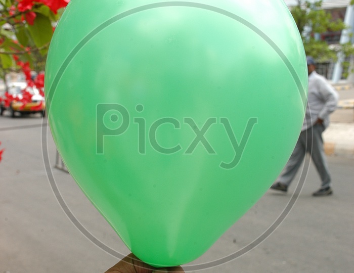 A green balloon in a hand