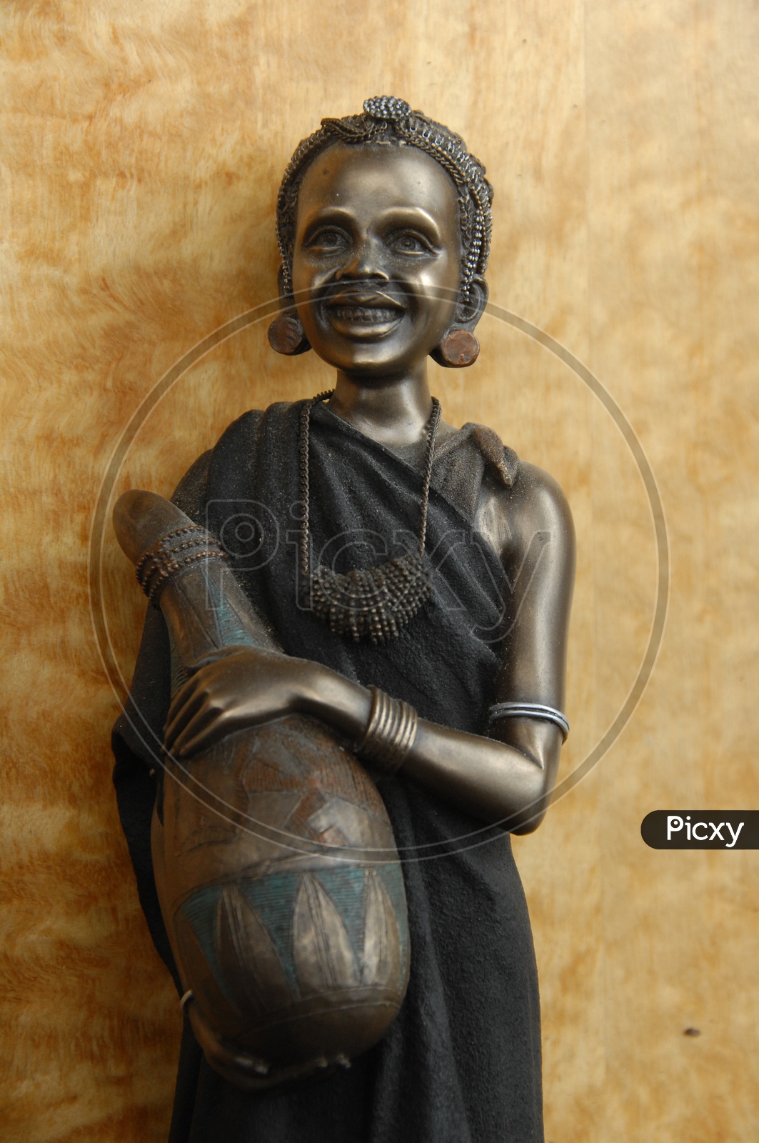 A smiling woman statue made out of metal
