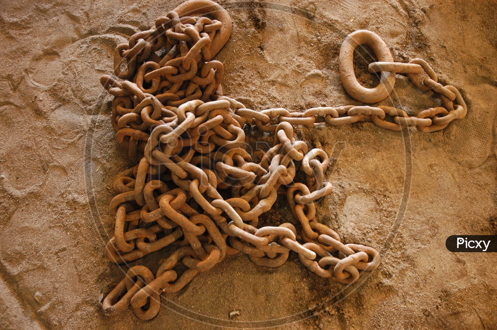 A rusted chain laying on sand