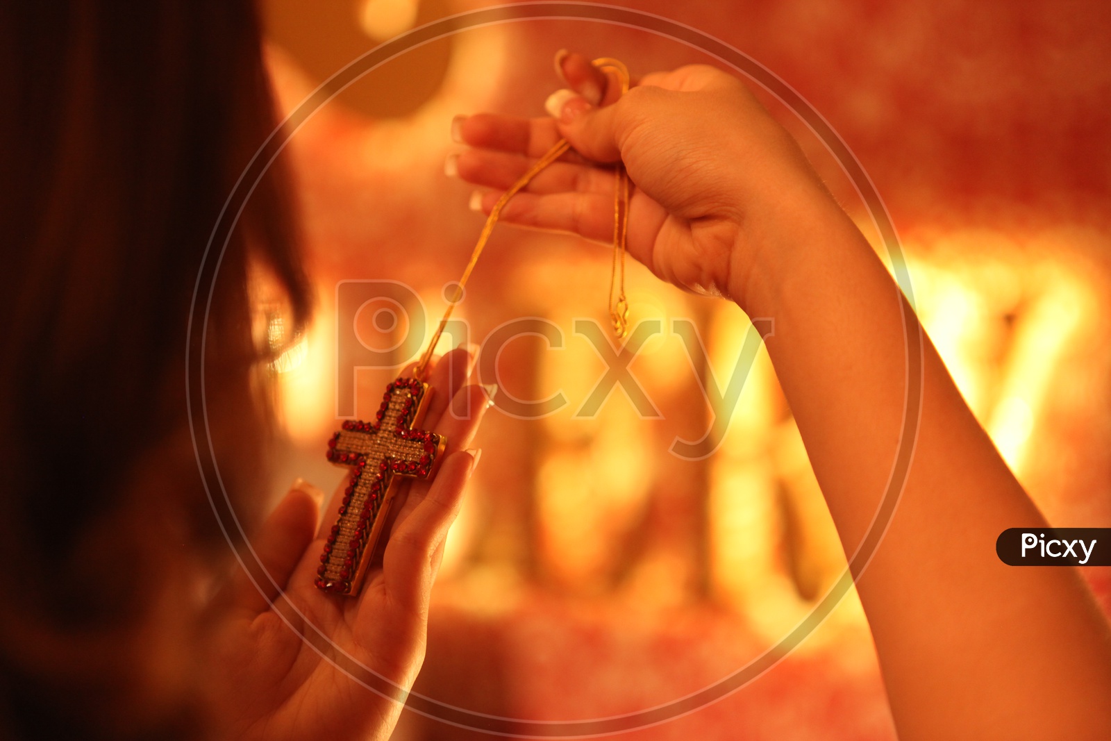A chain with a Cross locket in a woman hands