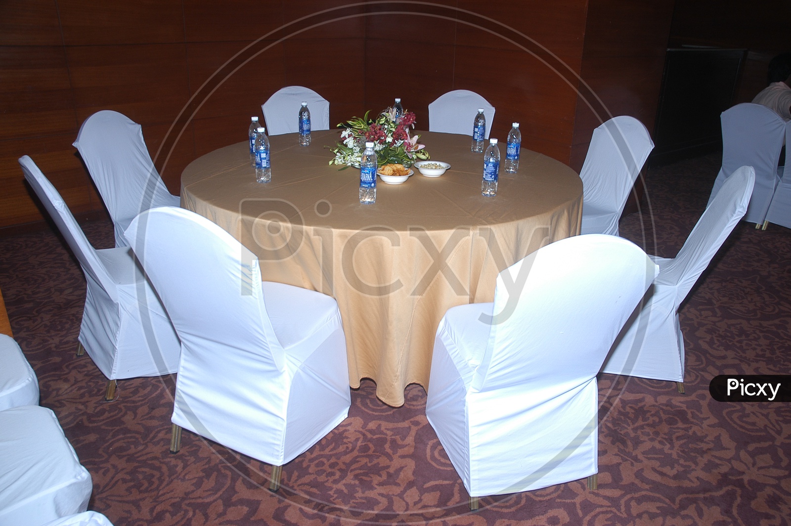 A Round Table With Chairs and Water bottles On The Table