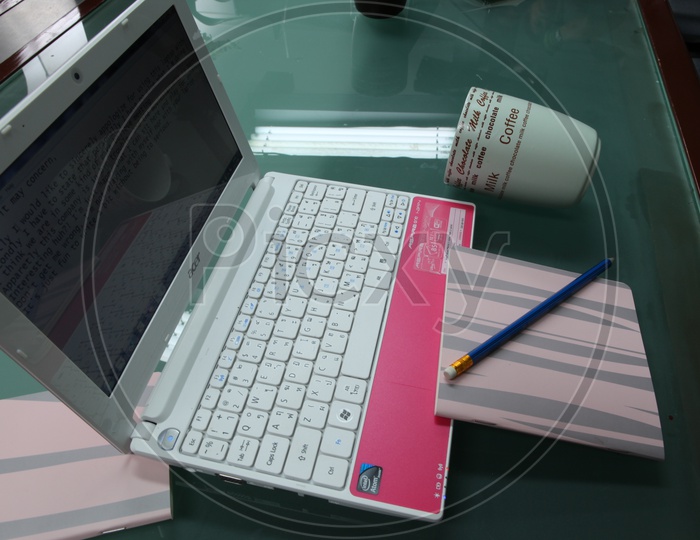 A Composition Shot Of a Working Table With Laptop , Coffee Cup  and Notebook With Pencil