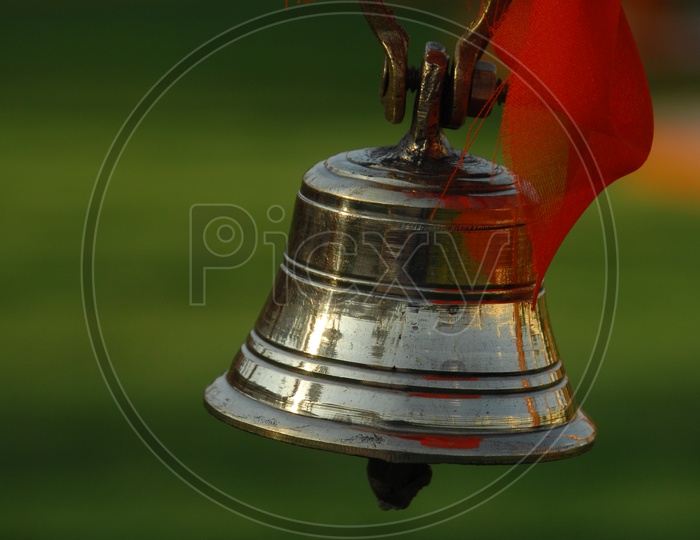 Metal bell tied to a rope with an orange cloth