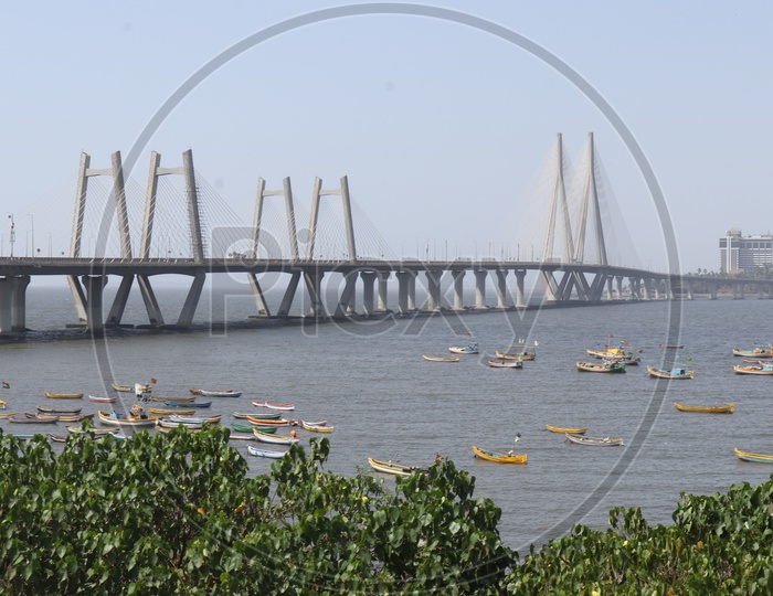 small boats sailing in Arabian sea with Mumbai Bridge in background