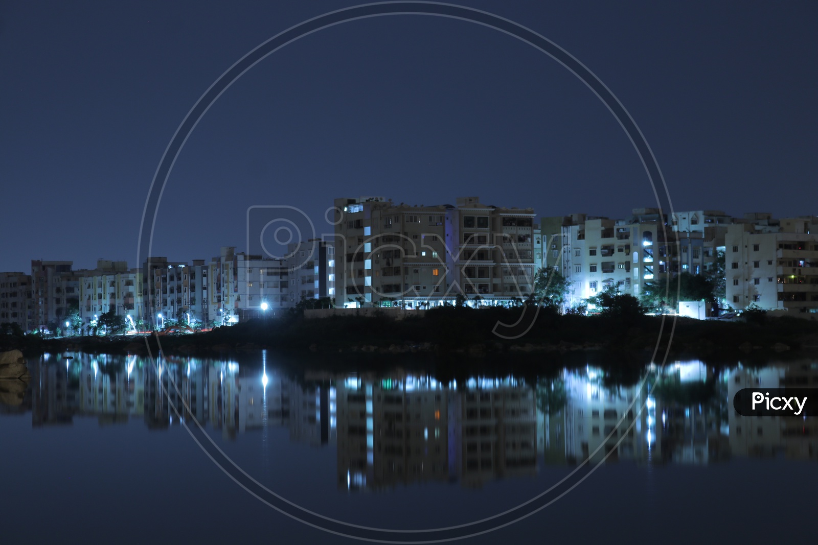 Reflections of buildings at Pragathi Nagar lake