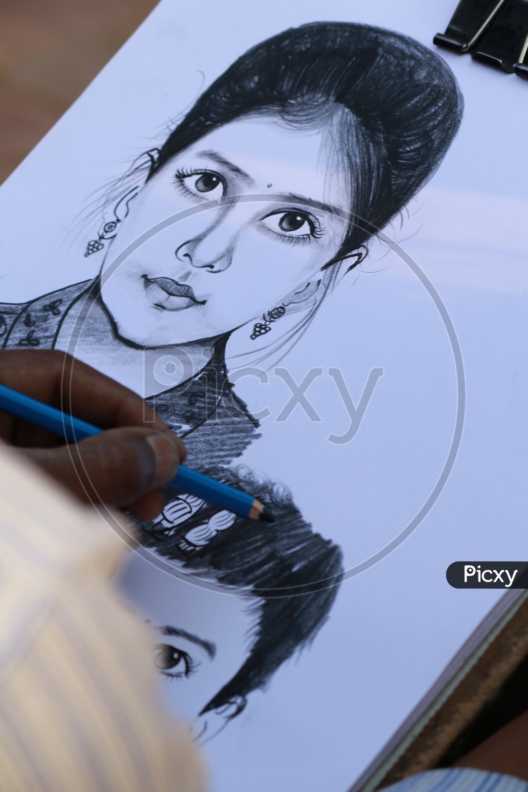 A person sketching a woman's portrait