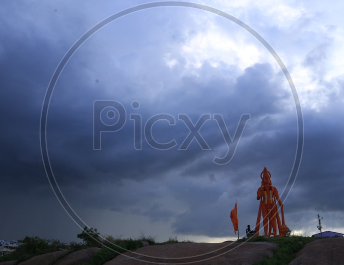 Hanuman Statue with clouds in the background