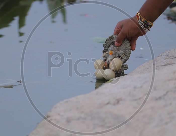 Clay Ganesh Idol immersion in a lake