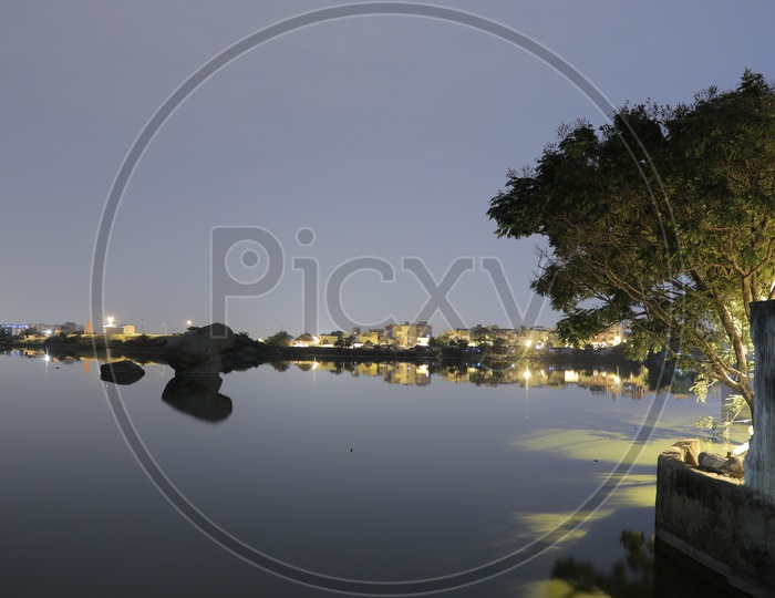 Reflections of buildings at Pragathi Nagar Lake at night
