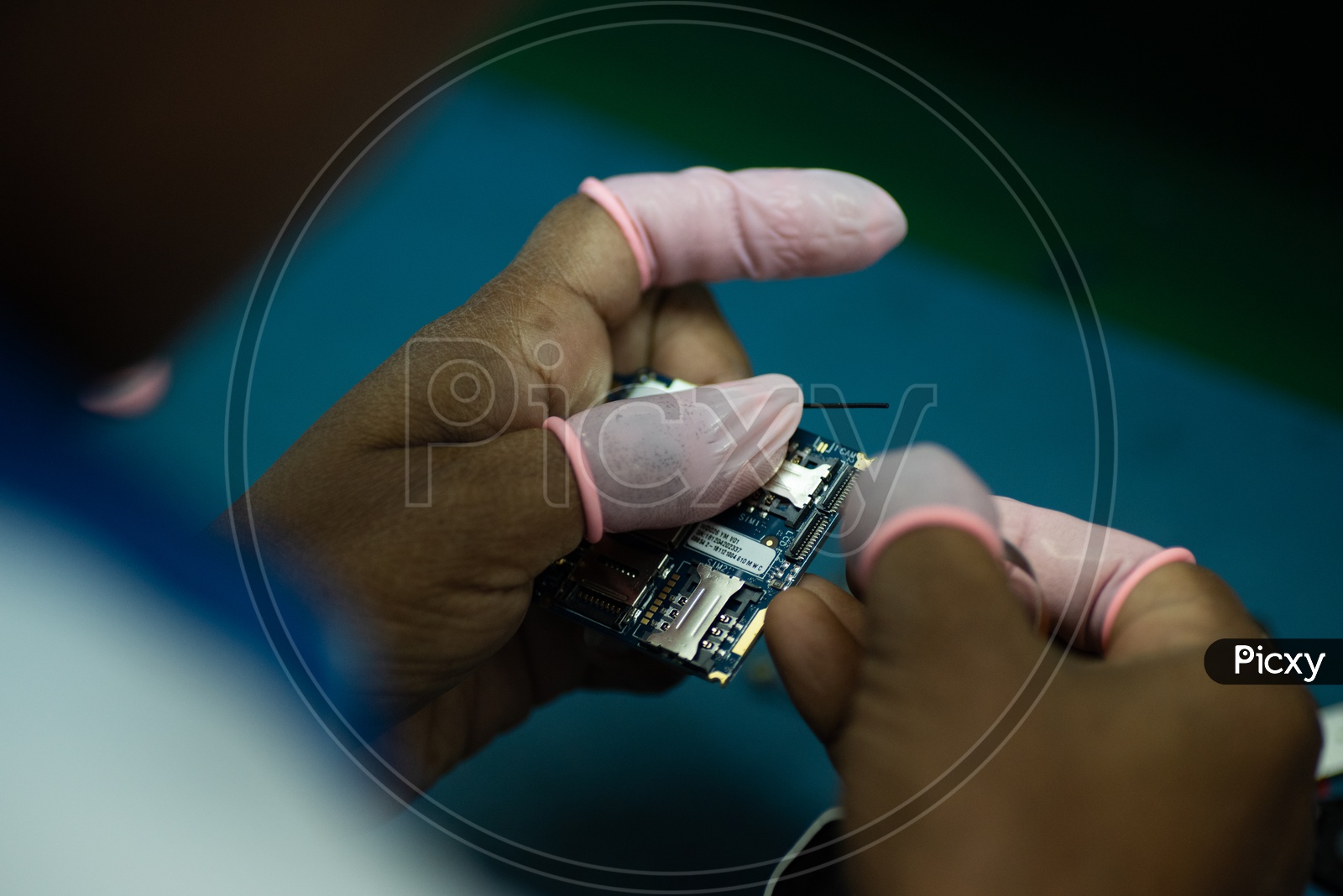 Technicians Manually Assembling The Micro Parts in a Phone Manufacturing Unit