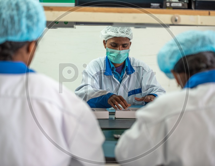 Technicians In a Mobile Manufacturing Unit Manually Assembling the Mobile Parts