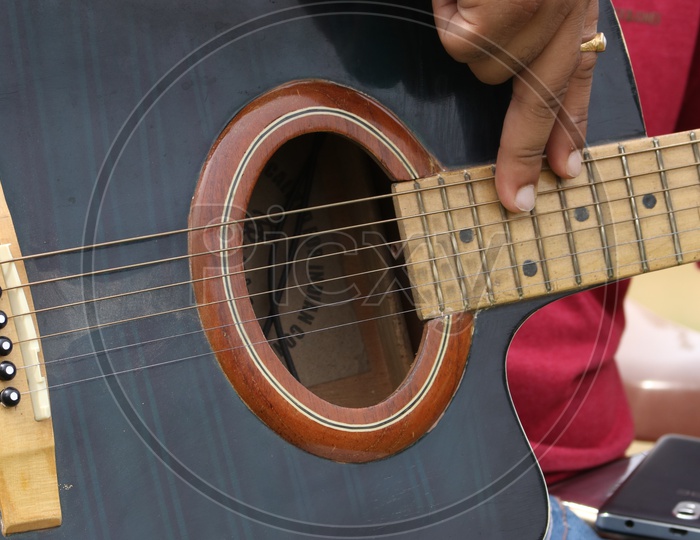A Closeup Shot Of a Man Playing Guitar