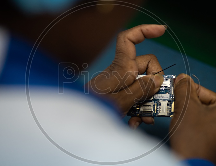 Technicians Manually Assembling of Mobile Parts In a Phone Manufacturing Unit