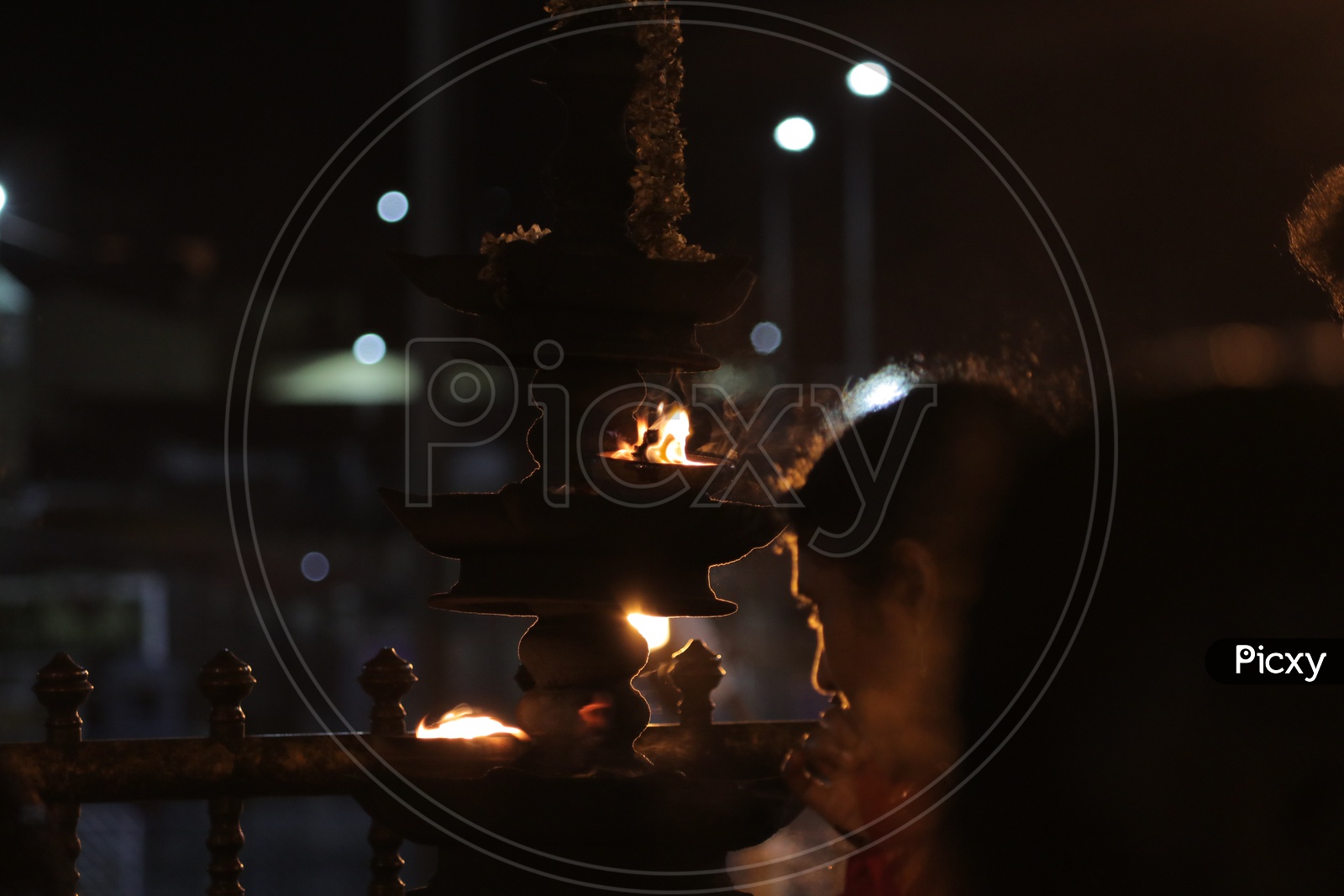 Devotee praying in front of aarti in a temple