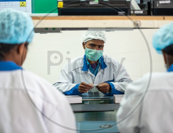 Technicians In a Mobile Manufacturing Unit Manually Assembling the Mobile Parts