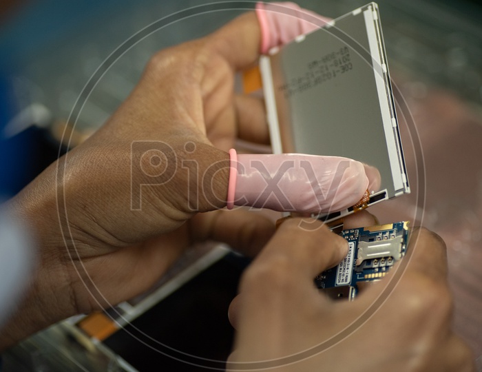 Technicians Manually Assembling The Mobile Parts in a Mobile Manufacturing Unit