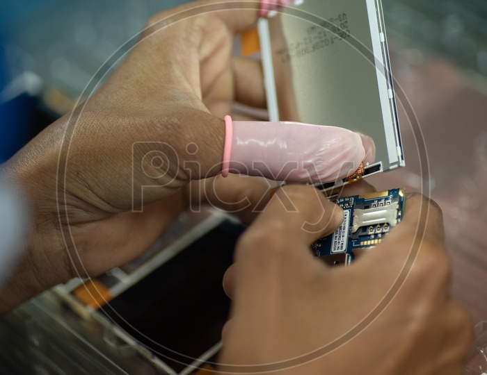 Technicians Manually Assembling The Mobile Parts in a Mobile Manufacturing Unit