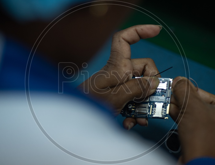 Technicians Manually Assembling of Mobile Parts In a Phone Manufacturing Unit