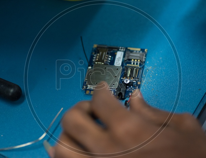 Technicians Assembling Micro Parts of Phones In a Manufacturing Unit